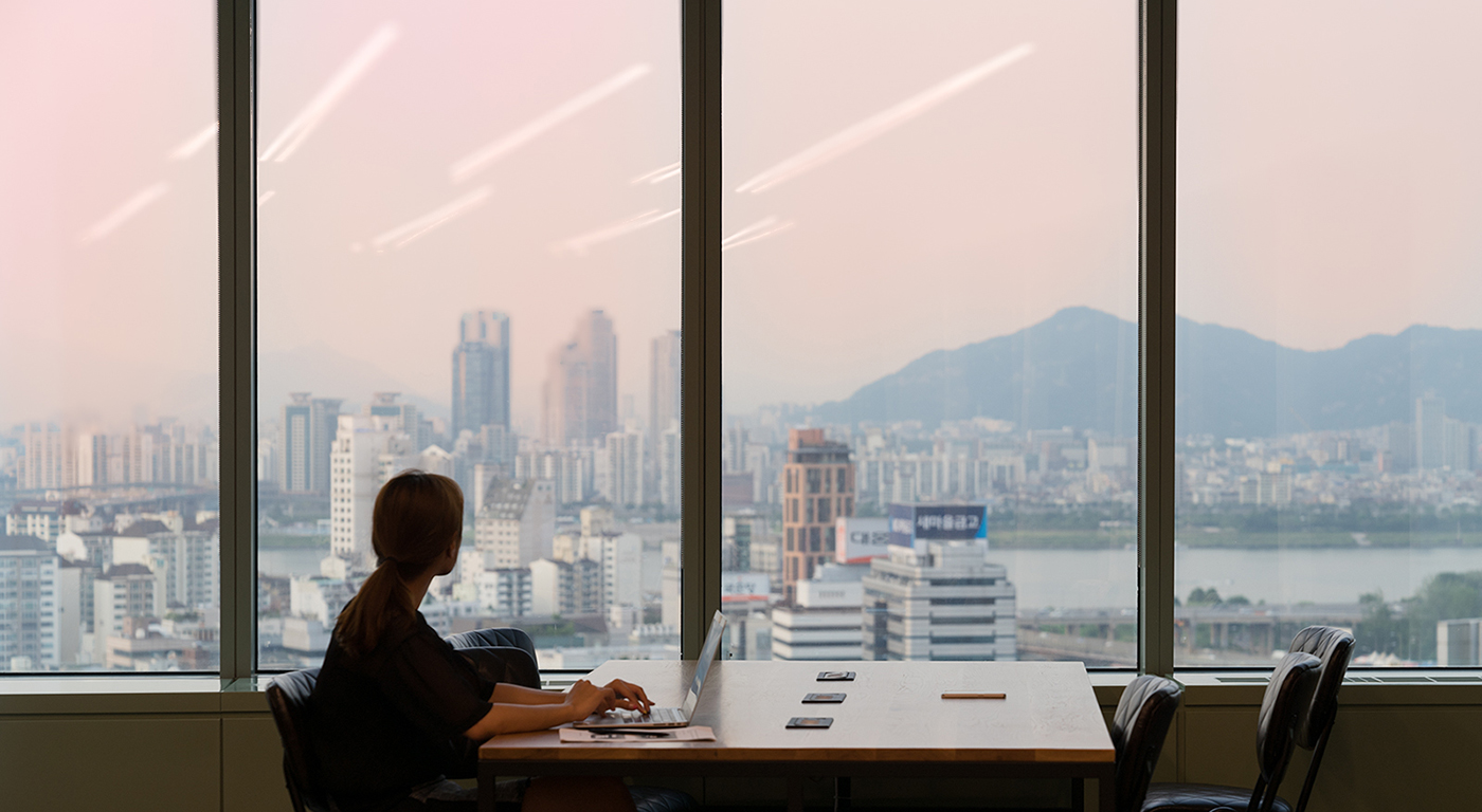 A business professional working at an office with city view